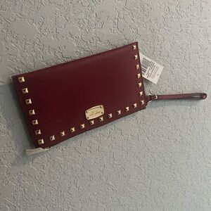 Brand new Merlot color wristlet with tags. Michael Kors